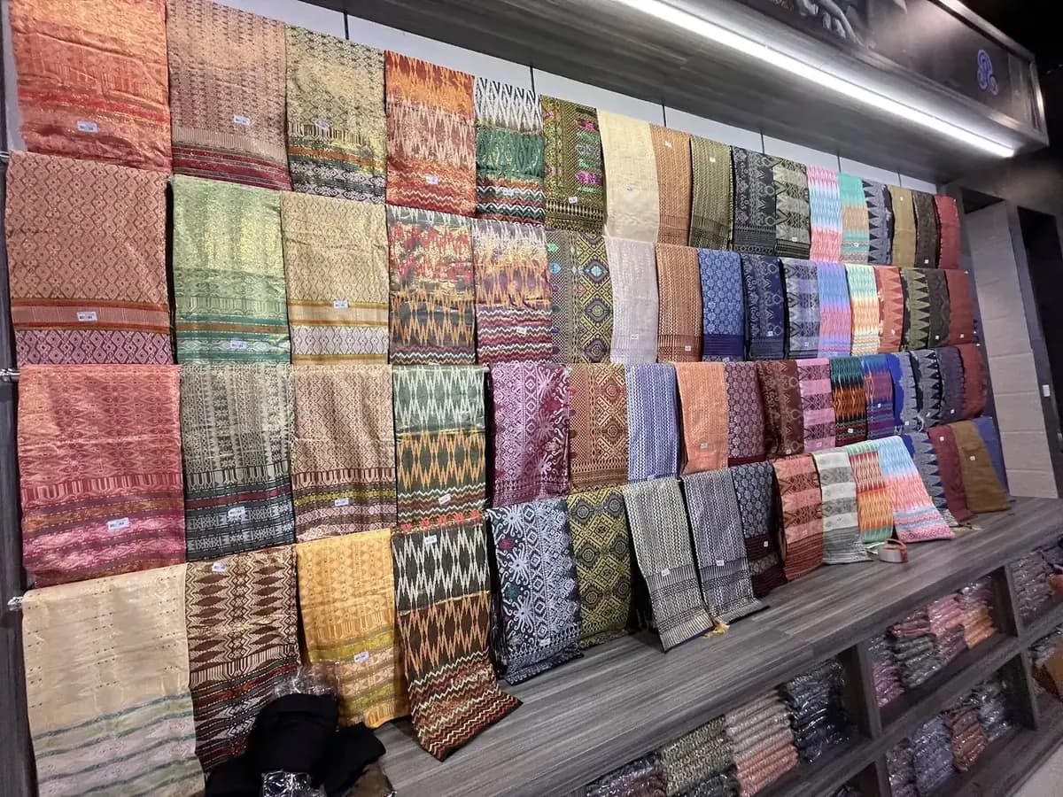 Kain-kain terlipat rapi di rak sepanjang dinding