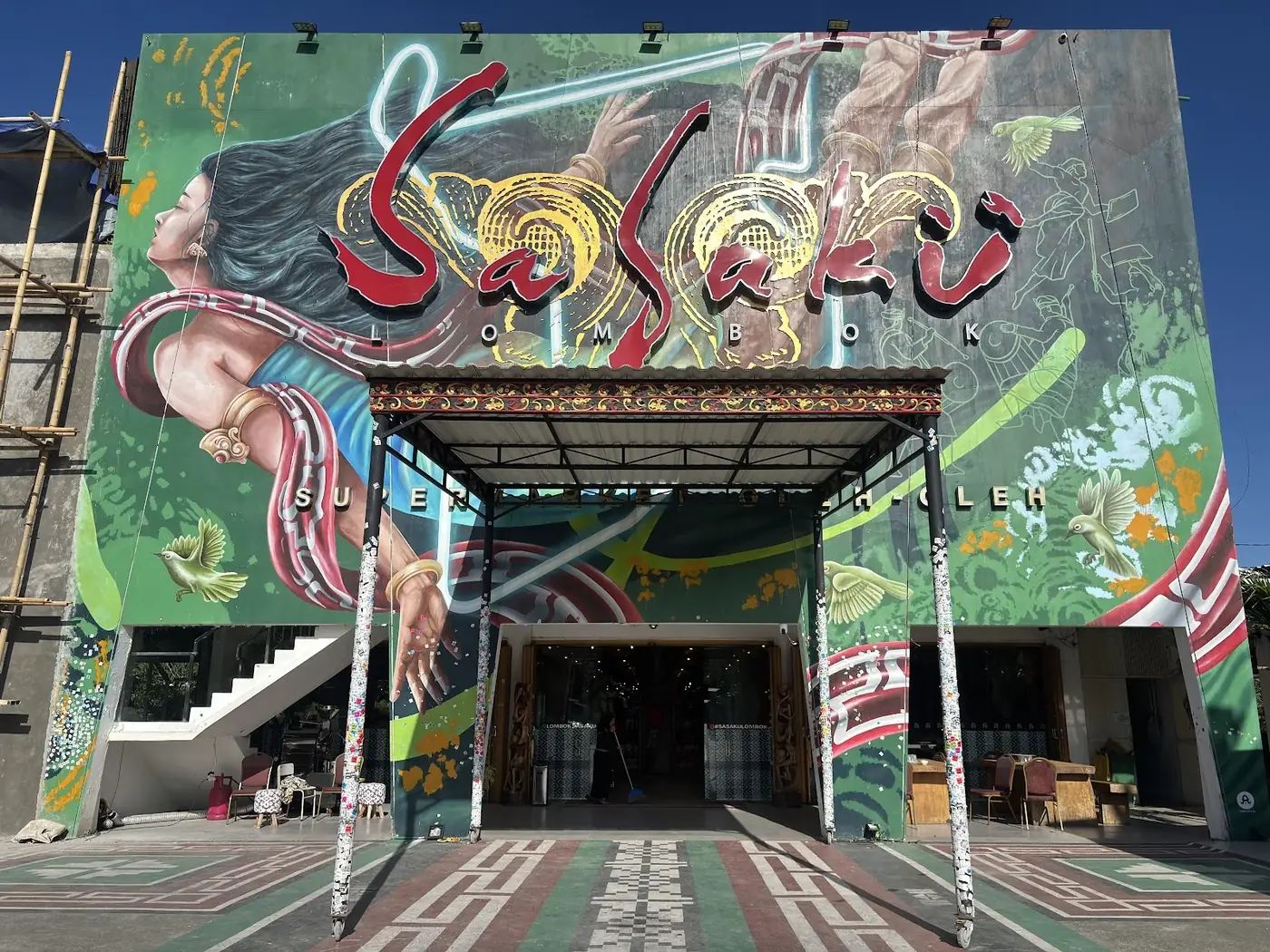 Bagian depan Sasaku Senggigi: dinding mural besar dengan tulisan Sasaku di atas pintu masuk