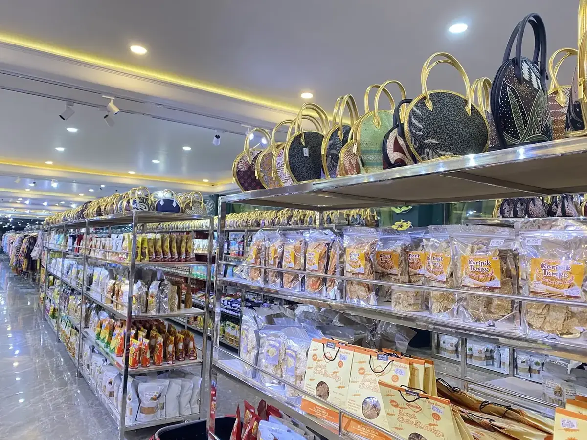 Lorong panjang toko dengan tas dan barang di rak atas